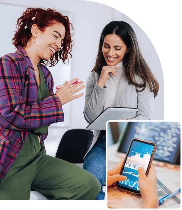 Two women smiling with tablet and phone.